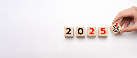 Hand Arranging Wooden Blocks Showing 2025 with a Target Symbol, Representing Goal Setting, New Year...