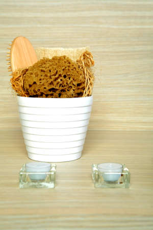 Spa and bath accessories in a bucket placed in on a shelf 