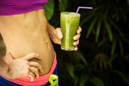 Athletic girl holding a green smoothieの写真素材