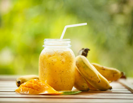 Smoothies mango and banana in a glass jarの写真素材
