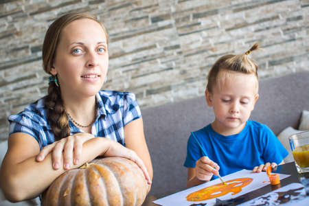 Mom with son draw  pumpkin for Halloweenの写真素材