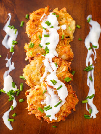 Fried potato pancakes with sour cream and green onionの写真素材