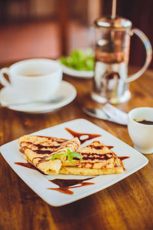 Pancake with chocolate sauce and green teaの写真素材