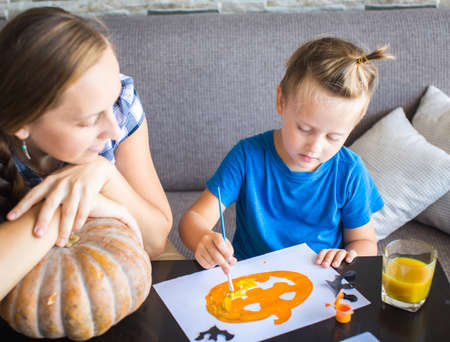 Mom with son draw  pumpkin for Halloweenの写真素材