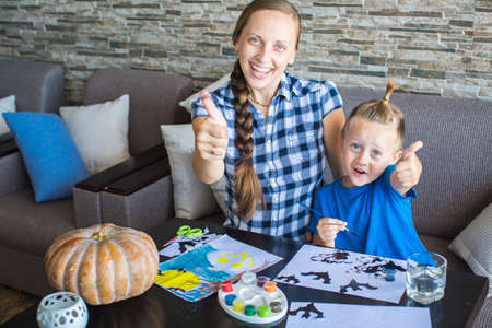 Mom with son draw  pumpkin for Halloweenの写真素材