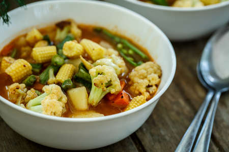 Steamed vegetables in a bowl on wooden tableの写真素材