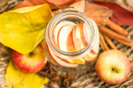 Detox water with apples. Autumn composition with leaves and apples.