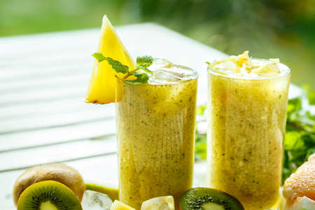 Smoothies of kiwi and pineapple on the tableの写真素材