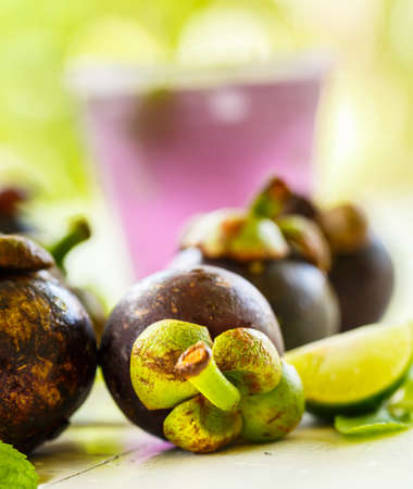 Mangosteen with mint leaves on a white table