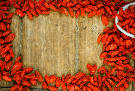 Frame of Goji berries on a wooden board.の写真素材