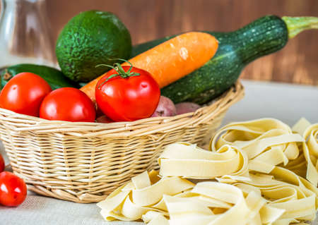 Composition with raw pasta,vegetables and olive oilの写真素材