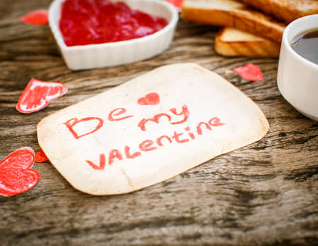 Toast with strawberry jam. Be My Valentine white message card with hand made hearts.の写真素材