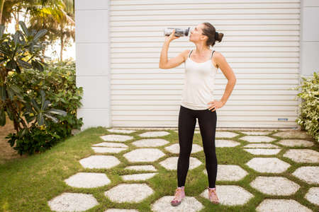 a girl drinks water after sport