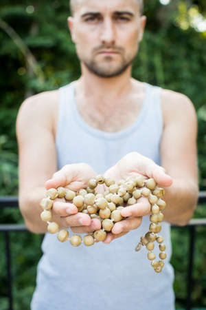 Young man holds a rosary in his hands and prayの写真素材