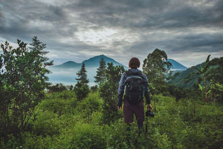 Tourist takes a snapshot of the Batur volcano from Kintamani, Bali, Indonesiaの写真素材