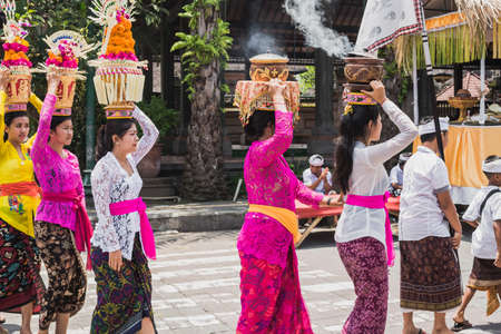 UBUD, BALI - MARCH 8: Village women carry offerings of food baskets on their heads in a procession to the village temple on March 8, 2016 in Ubud, Bali, Indonesia.のeditorial素材