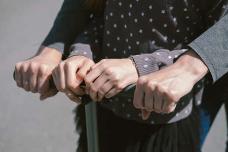 Mother and daughter ride on a scooter in the cityの写真素材