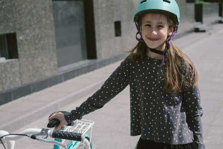 Teenage girl resting in a street with a bicycle