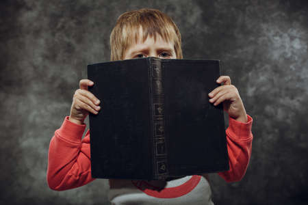 Boy 5 years with books  sitting on a chairの写真素材