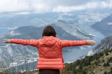 Happy free woman enjoying trip adventure travel with open arms up showing freedom in mountainの写真素材