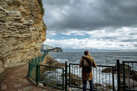 Traveller man with backpack enjoying view of seaの写真素材