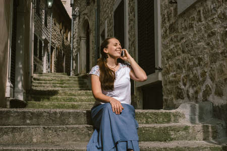 Beautiful woman talking on mobile phone in old city