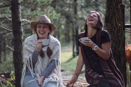 Girlfriends drinking coffee on nature in the country. Folk styleの写真素材