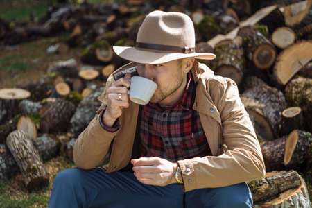 Man cowboy hat drinking morning coffee in countrysideの写真素材