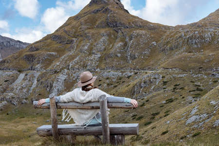 Back view of  young lady with hat and warm poncho on mountain landscape, Durmitor, Montenegroの写真素材
