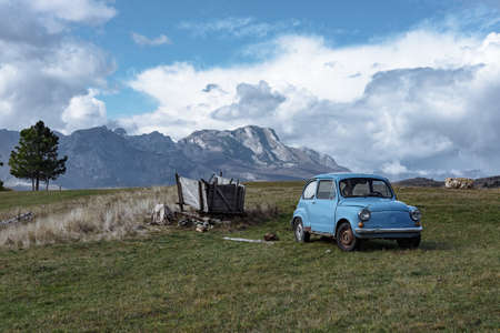 Old blue car on a background of beautiful mountainsの写真素材