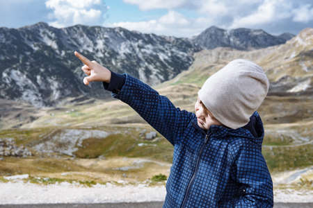 Little explorer hiking in autumn mountainsの写真素材