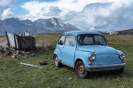 Old blue car on a background of beautiful mountains