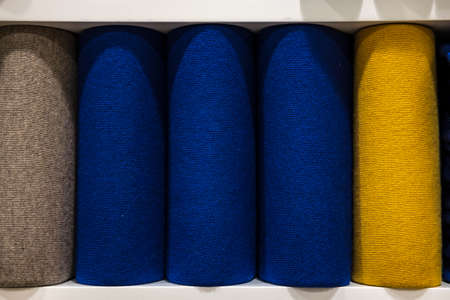 Colorful sweaters in a big supermarket. Beautifully stacked woolen thingsの写真素材