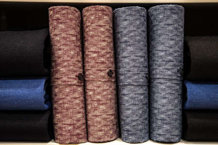 Colorful sweaters in a big supermarket. Beautifully stacked woolen thingsの写真素材