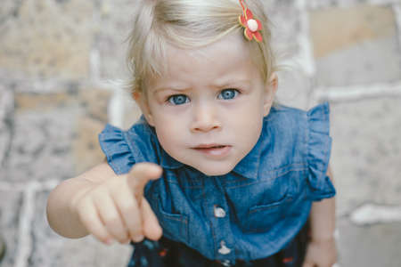 Cute girl reaching finger to camera, pointing.の写真素材