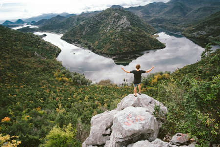 Man traveler sitting on the mountain and gaping, freedom concept
