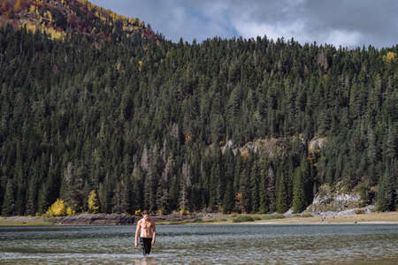 Hardening in cold water. Man bathes in the lake autumn in Montenegro, Durmitor Parkの写真素材