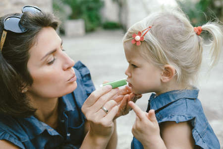Portrait of a happy family: young beautiful woman with her little cute daughter. Fashion family concept の写真素材