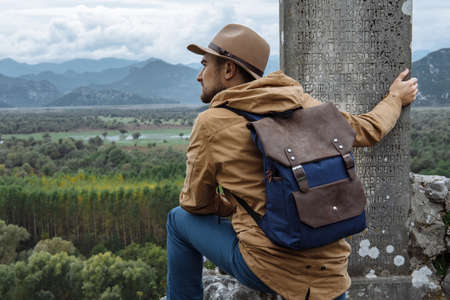 Man traveler with hat and backpack enjoying the natural surroundingsの写真素材