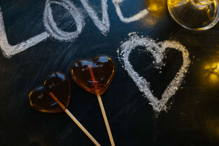 Closeup Word love, Heart shape lolipops,  lights on black background.の写真素材