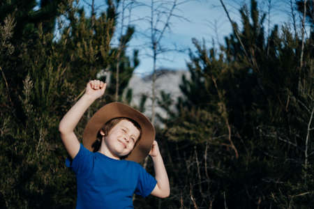Happy Smiling boy outdoor in summer forest. 6 years old kid in hat playing in nature. Copy spaceの写真素材