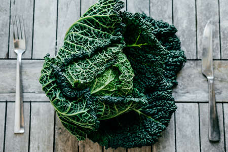 Fresh Green Kale most useful vegetables on wooden background with a fork and knifeの写真素材