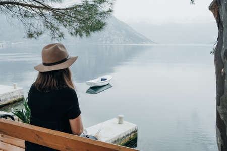 Copy space. Travel woman in a hat enjoys a view of the bay in Montenegro. Back viewの写真素材