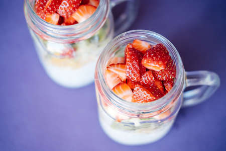 Top view Chia seed pudding with Strawberry, kiwi, orange served in a Mason Jar on violet backgroundの写真素材