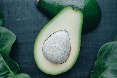 Cut fresh avocado on a black boardの写真素材
