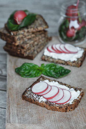 Fresh Vegetable Sandwich with cottage cheese, radish and basil on rustic wood background, closeupの写真素材