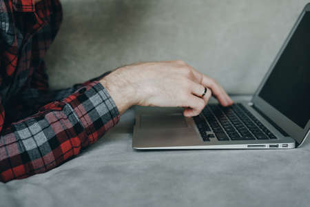 Close up Hipster man in red socks working at laptop and lying  on the couchの写真素材