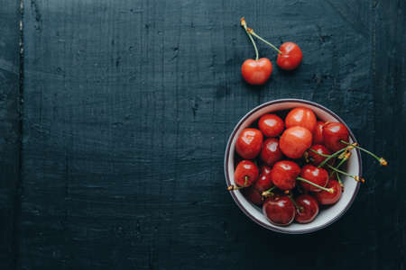 Copy space, Top view. Cherries in bowl on black backgroundの写真素材