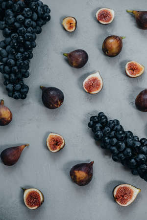Top view of cutting Figs  and dark grapes on a gray background. Autumn harvest