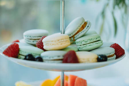 Closeup colorful macaroons, fruits and cake on Sweet table